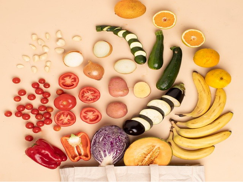 canvas bag with produce neatly spilling out arranged by color